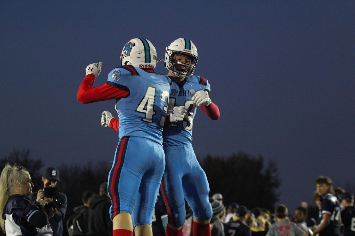 Brothers senior Dominic Lyons (43) and junior Jacob Lyons (19) collide in the air after running through the tunnel of players on Friday, Oct. 4. 