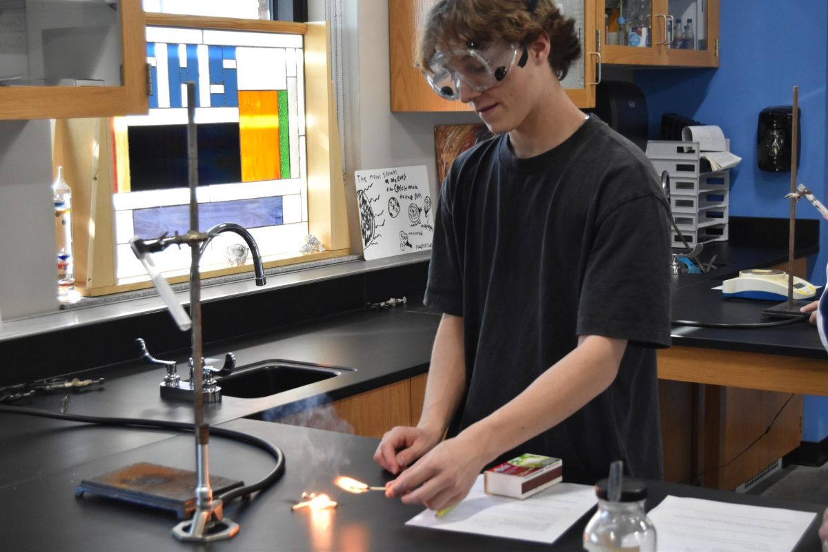 Junior Kevin Heinbuch starts fire for chemistry lab on Oct. 11 in chemistry teacher Tyler Ross’ classroom. (Bella Thompson, Makaela Reinke)