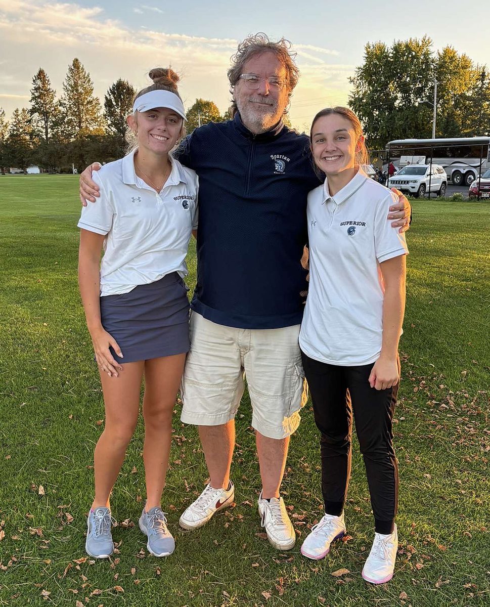 Seniors Brynn Johnson (left) and Tara Stratton pose with head coach Ed Willie (middle) on Sept. 23 in Ladysmith after their meet.