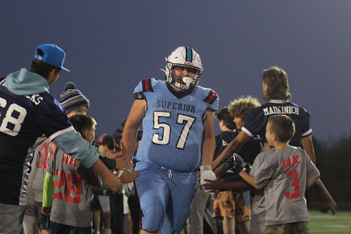 Freshman Caiden Izzard runs through the tunnel of players at the homecoming game on Friday, Oct. 4. 