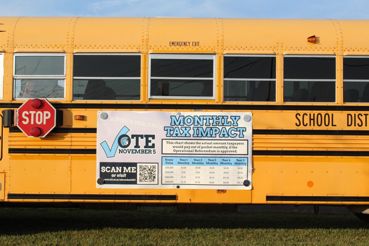 Sign outlining monthly tax impact of the referendum sits on the outside of a school bus in the parking lot of Superior High School on Oct. 21.