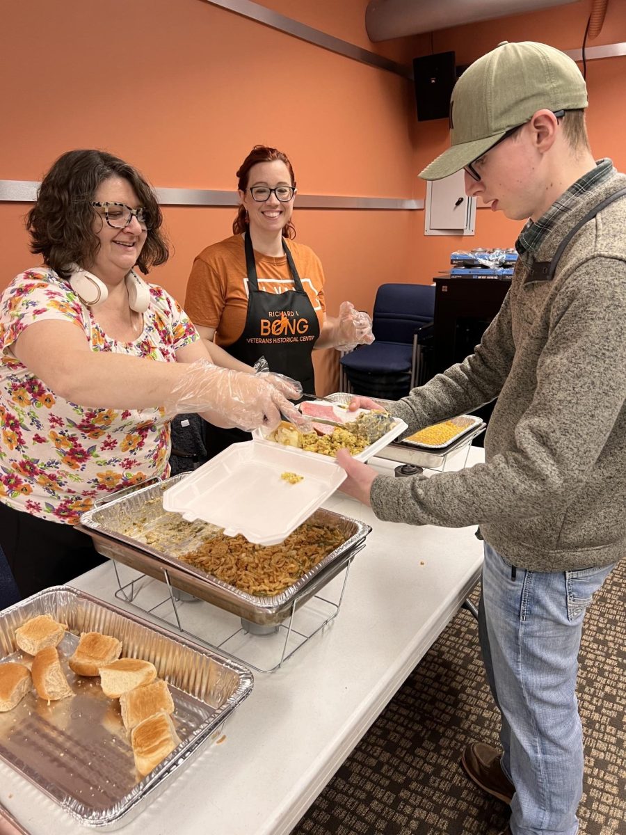  Dale Summerfield Jr. filling a plate with food to serve to a veteran, on Nov. 28, 2024 at the Richard I. Bong Center.