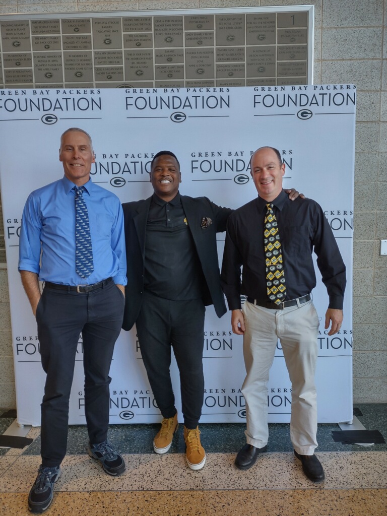 Swim coach Bill Punyko (left) poses next to Defensive Safety Leroy Butler (center) and Stefan Pagnucci.