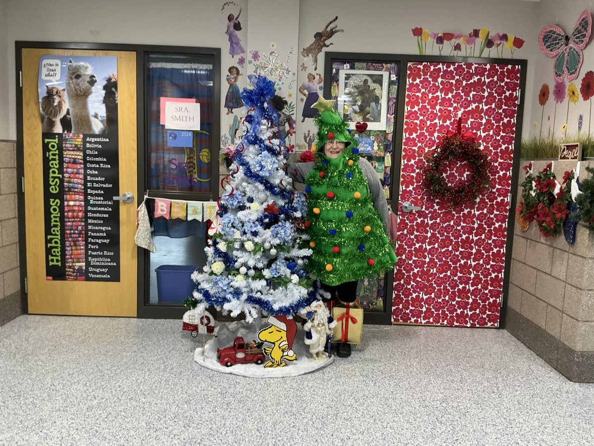 Business teacher Donna Stubbe poses outside of classroom 2114 next to a tree on Dec. 19.
