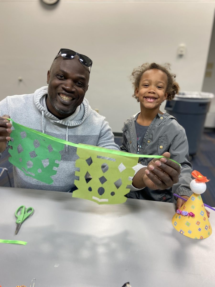 A child is holding her papercutting with her dad in Superior Public Library on October 4th.
