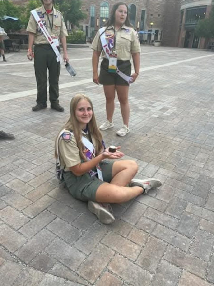 Sophomore Gabriella Rusk sits on the ground holding a mini cake on July 30, 2024 in Boulder, Colorado.
