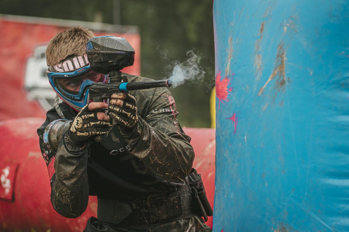  Senior Jackson Nelson aims from around the corner of an obstacle, kneeling at Cousins Paintball Park outside of Dallas on June 1. 