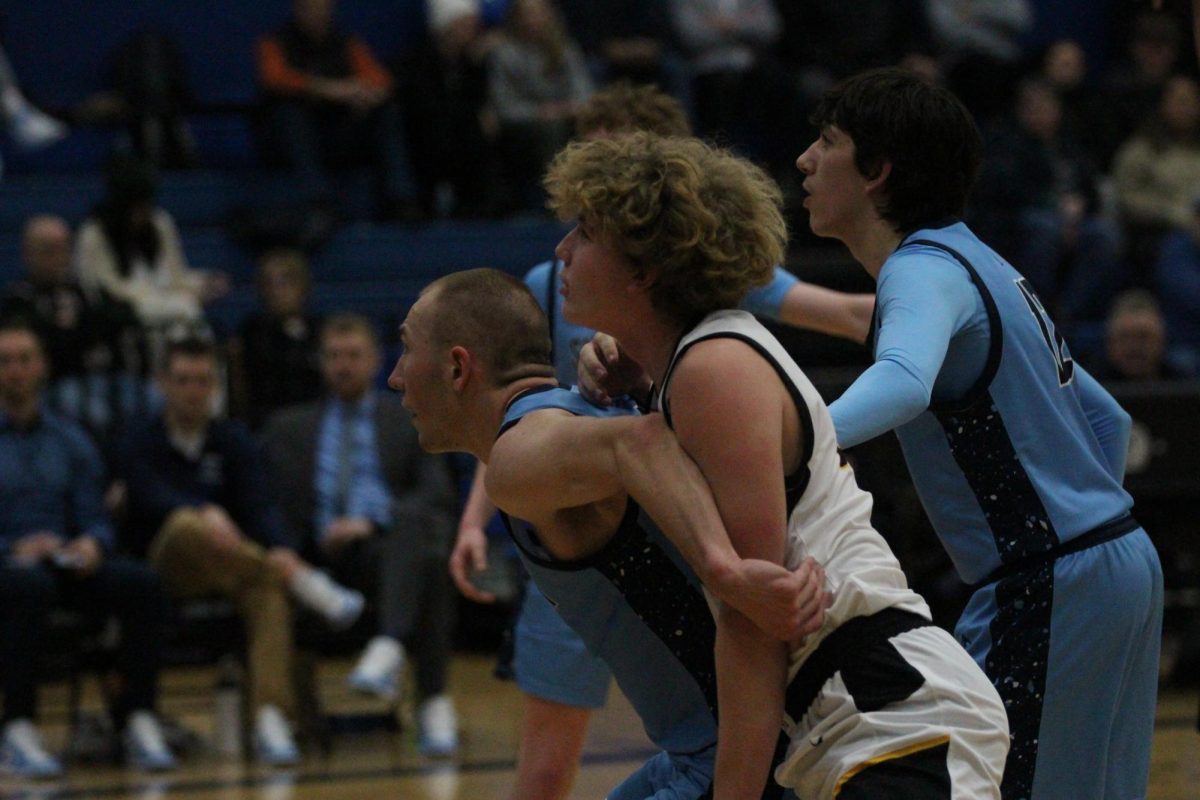 Junior Drew Eisel boxes out player from Marshall on Thursday, Feb. 6. The boys team played in the second game of the double header.