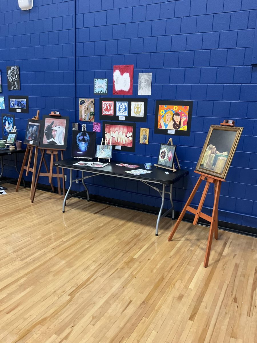 Reporter Maddy Bachand takes pictures of spartan fiesta on May 7, 2025. A variety of artwork is displayed during the fiesta. 
