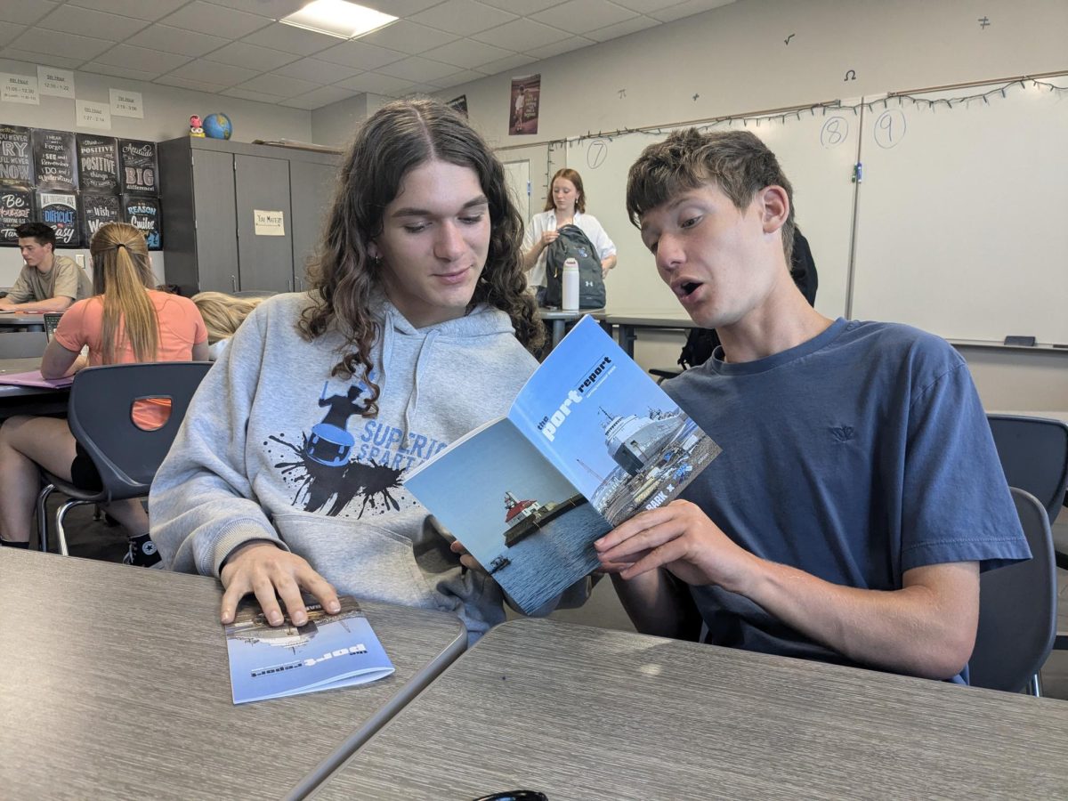 Juniors Milo Peterson (left) and Jackson Mueller (right) read the port report magazine on May 13, 2025. The port report was made in collaboration with the bark, a journalism program at UMD. 