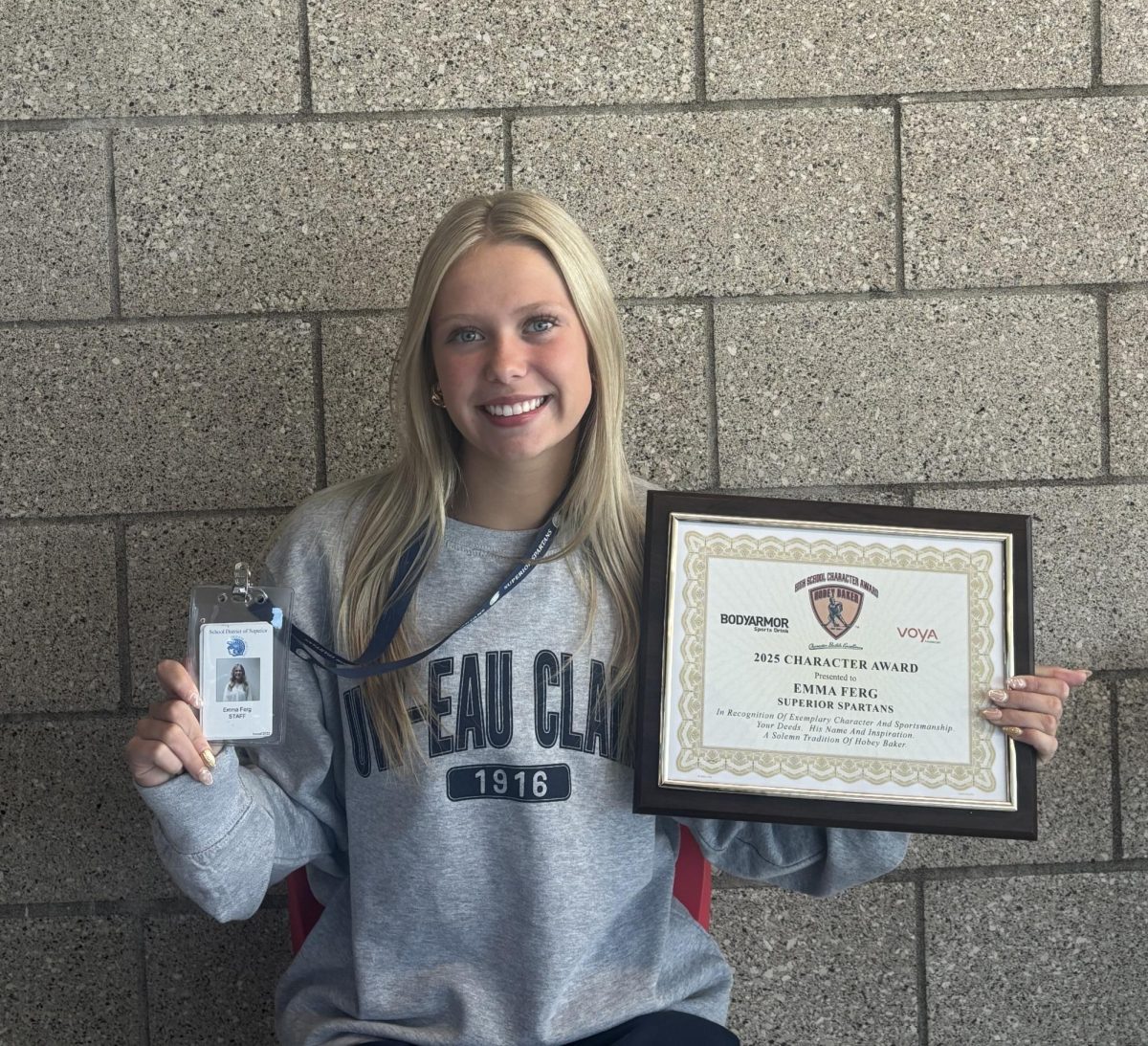 Senior Emma Ferg poses with her Hobey Baker Award and Great Lakes Elementary badge on April 30, 2025.