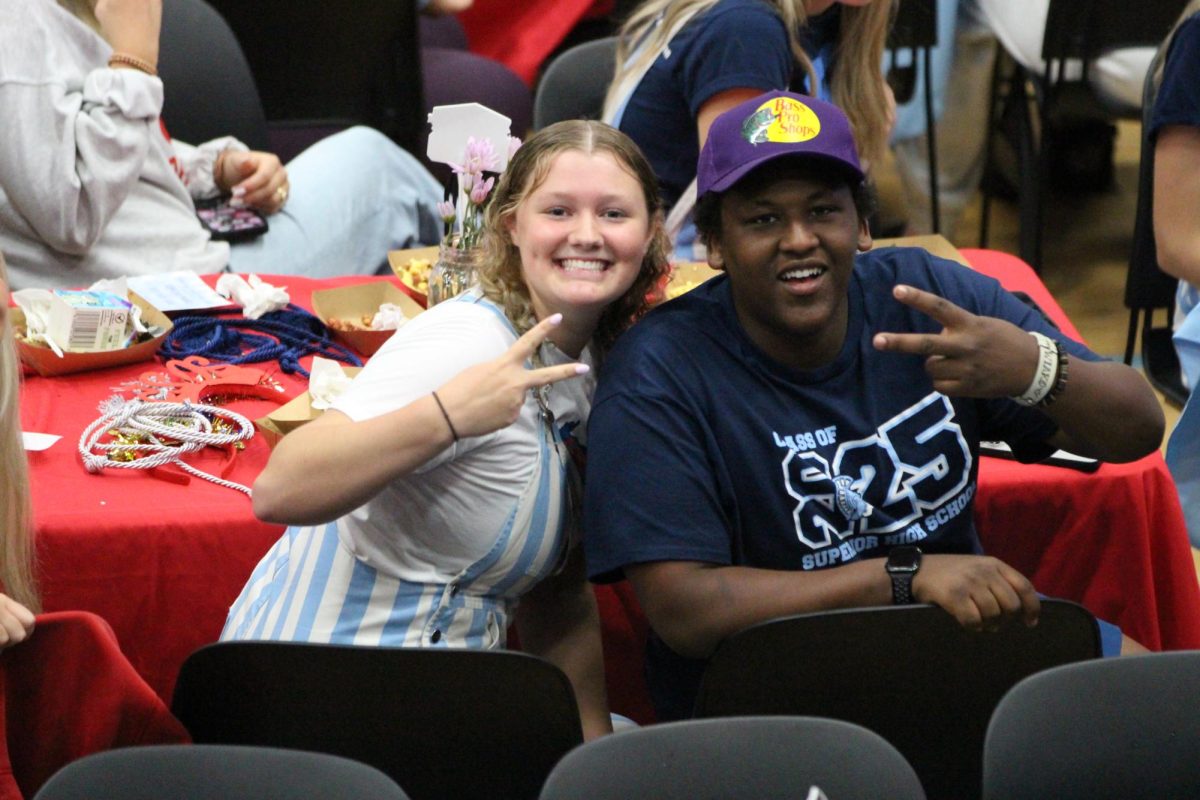 Seniors Addy Golat (left) and Wyatt Franzen throw deuces during the senior brunch in the Spartan Arena on Friday, June 6, 2025. The seniors were outside practicing for the graduation ceremony in the rain before coming in to celebrate. 