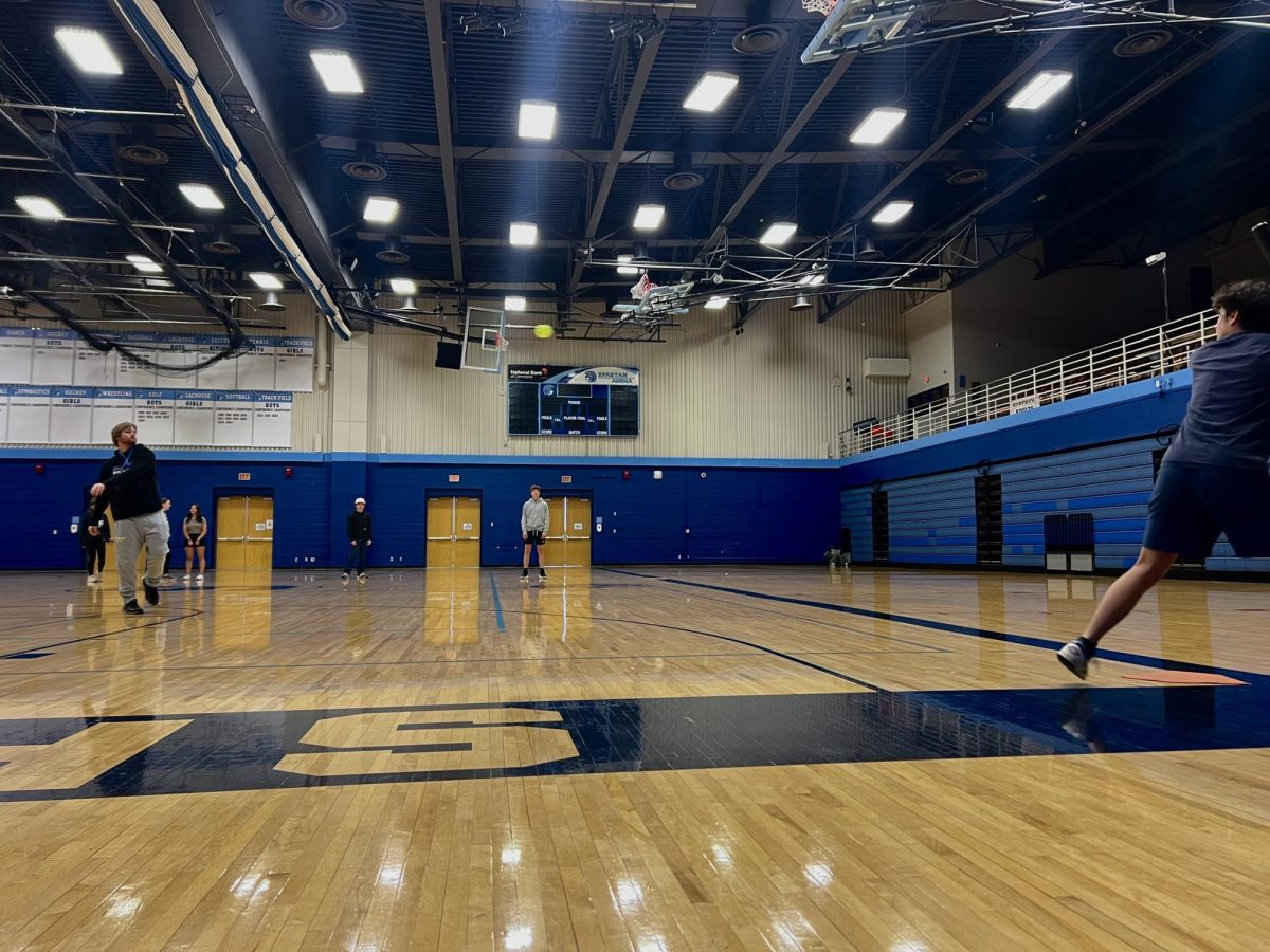 Coach Gunner Johnson throws a whiffle ball to sophomore Jacob Penny during gym class on May 22, 2025. The gym classes spent the day playing indoor whiffle ball. 