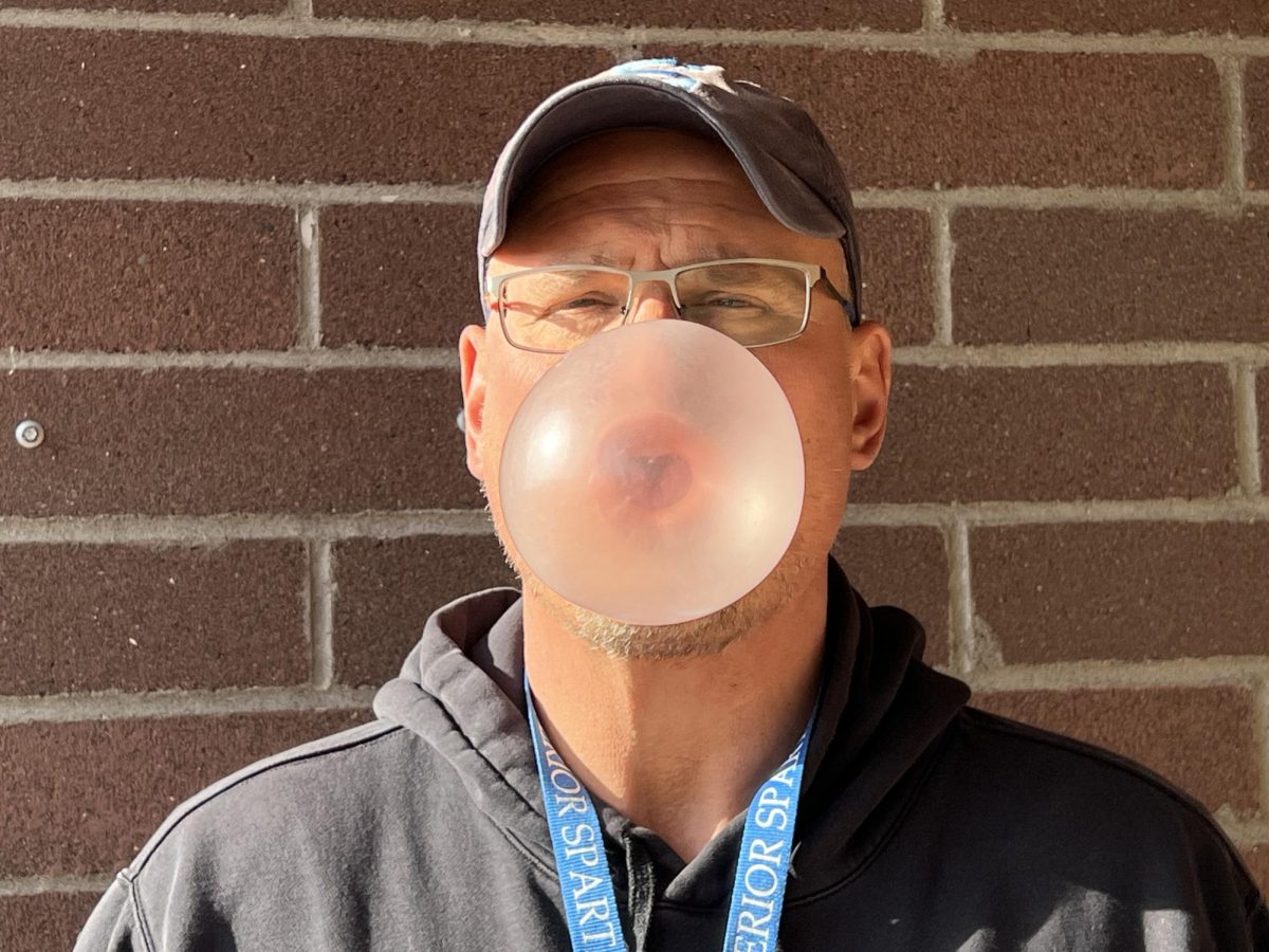  John Heinen blows a bubble in the softball field dugout on April 23, 2025