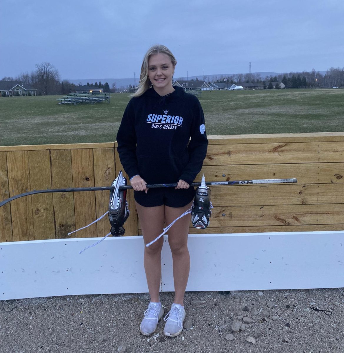 Senior Bella Thompson poses at the Billings park outdoor ice rink on May 5th 2025. Along with Bella and her skates and stick from her high school season. 