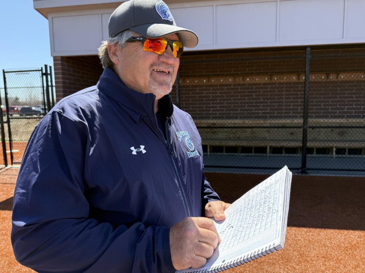 JV assistant coach Dave Sigfrids looks out onto the field while working on the scorebook at the NBC Spartan Sports Complex on May 8, 2025.