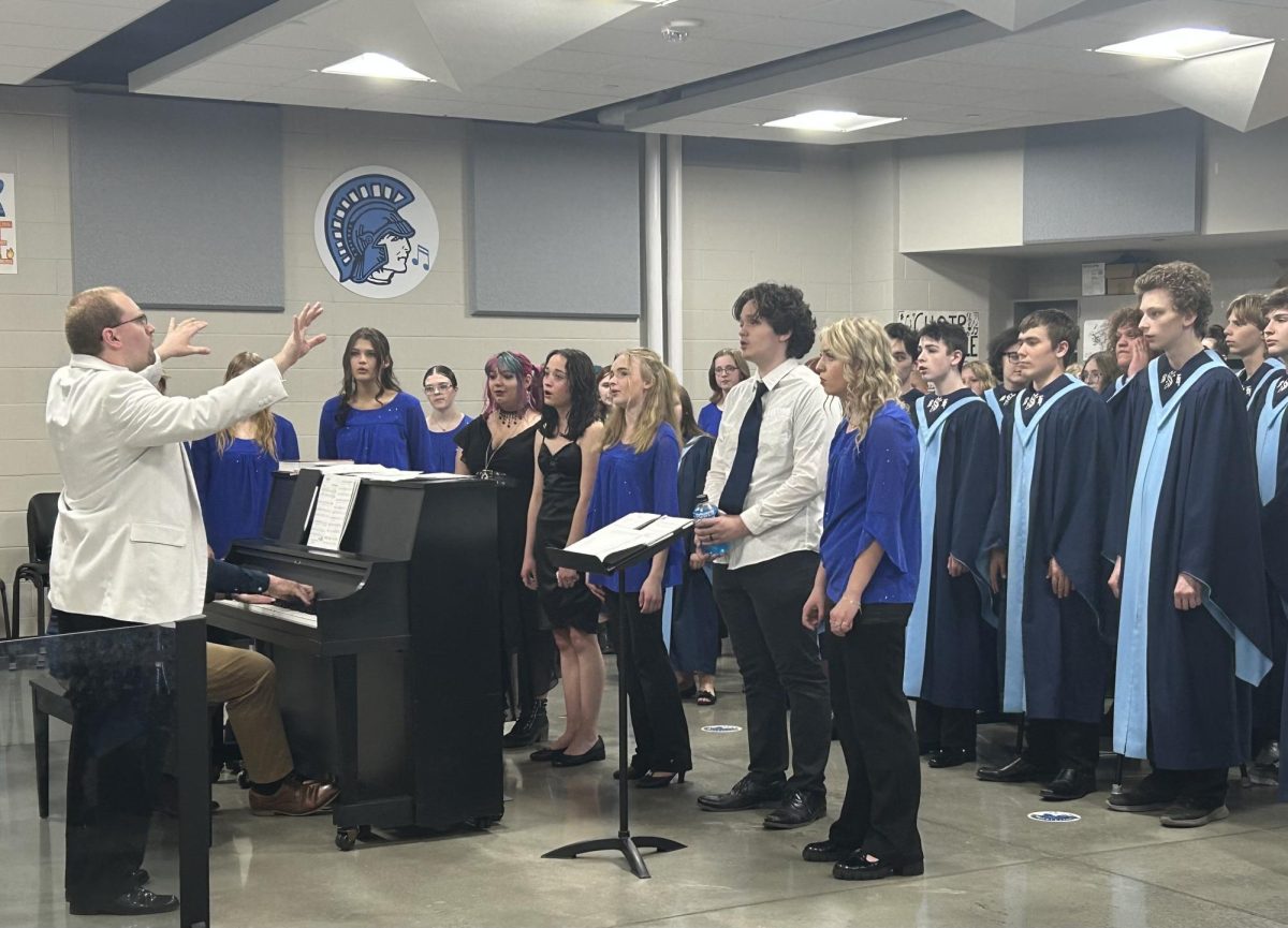 Choir director Timothy Delnay conducts the Spartan choir in the choir room on April 28, 2025. The seniors in the choir are practicing for their solos in the concert being held that night. 