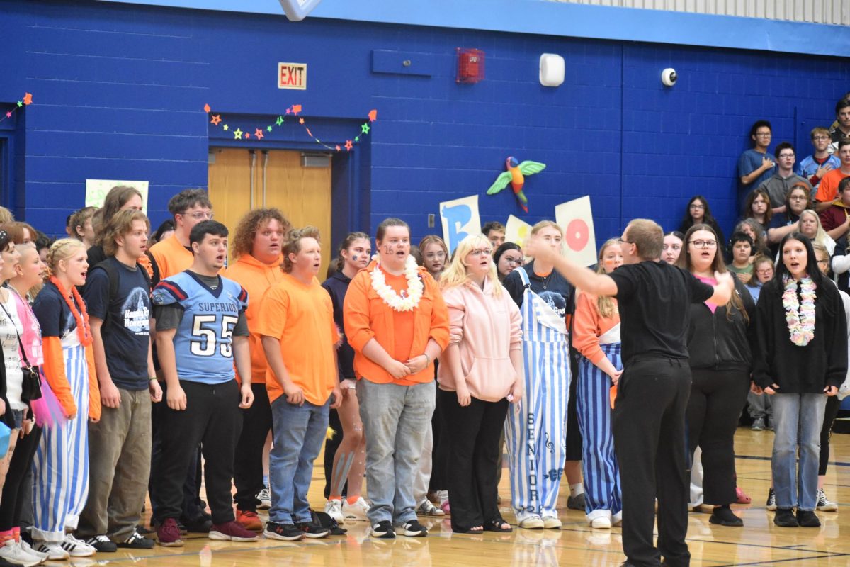 Spartan Singers, conducted by Timothy Delnay (front), embrace Spartan pride by singing the school song during the Homecoming Assembly on Sept. 27, 2025. Choir members utilize harmonies to give the song a new life and evoke school spirit. 