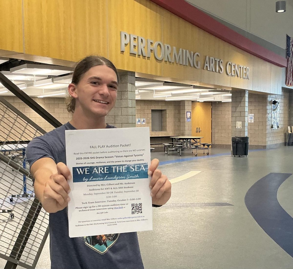 Senior technician Milo Peterson holds out audition packet in front of the Performing Arts Center on Sept. 25, 2025. Peterson is the light and sound manager for the upcoming fall play “We Are the Sea.”
