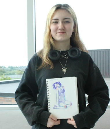 Sophomore Allison Maki smiles for the camera while presenting a simple sketch on Oct. 1, 2025.
