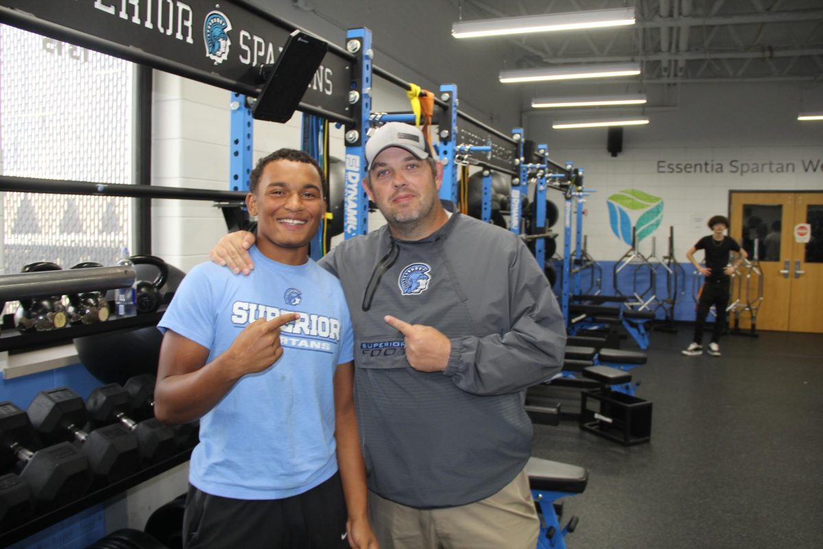  Football player Maxton Luzaich (left) poses for a picture with head Spartan football coach Rob Scott (Right) in the weight room at Superior High School. 
