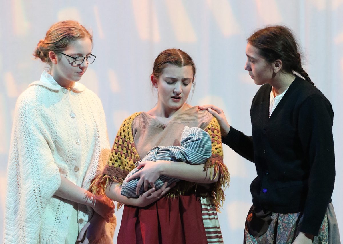 Senior actresses Joy Becken (left), Jade Ludwig (center), and Lili Sakuray (left), stand in the middle of the stage, during a scene from “We Are the Sea,” on Nov. 21. 
