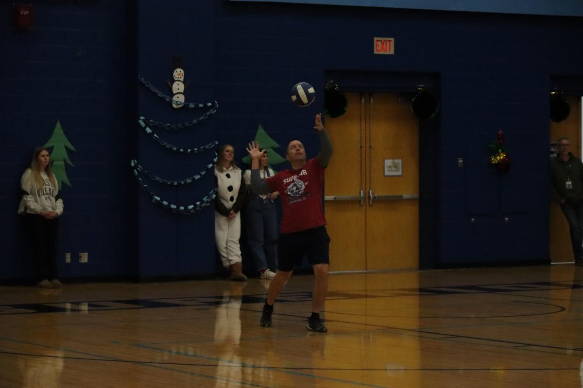 Teacher Kyle Smith serves the ball for the teacher team on Dec. 19