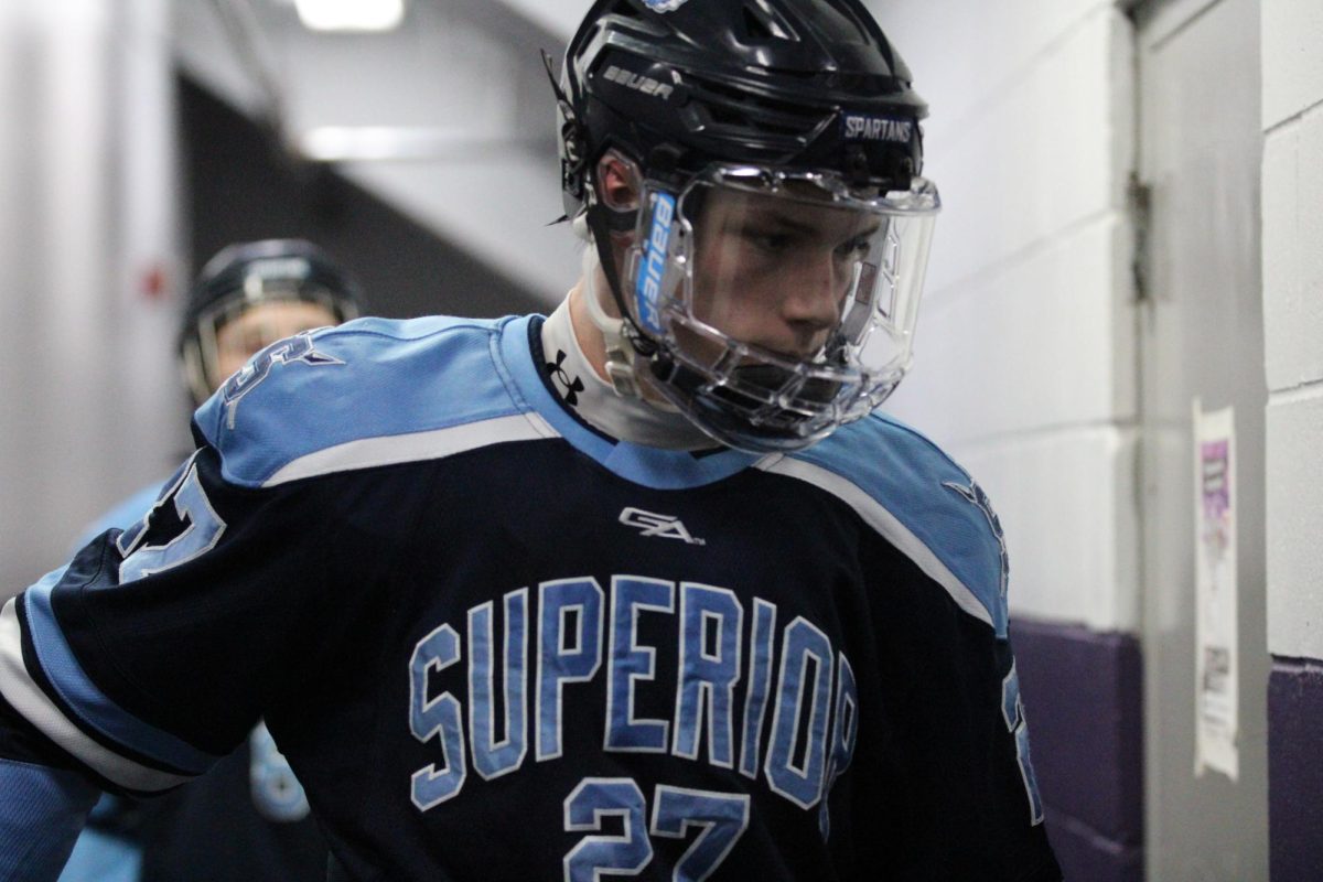Senior Maverick Milroy walks in the Wessman Arena hallway to start the second period on Jan 27.