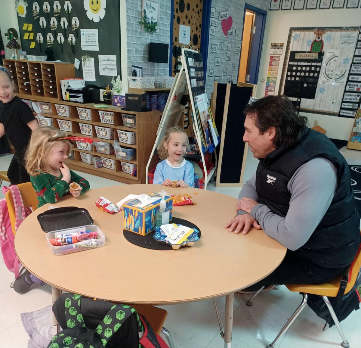 Ryan Haroldson talking with Great Lakes first graders during after school program about their upcoming Christmas plans on Dec. 17 2025.