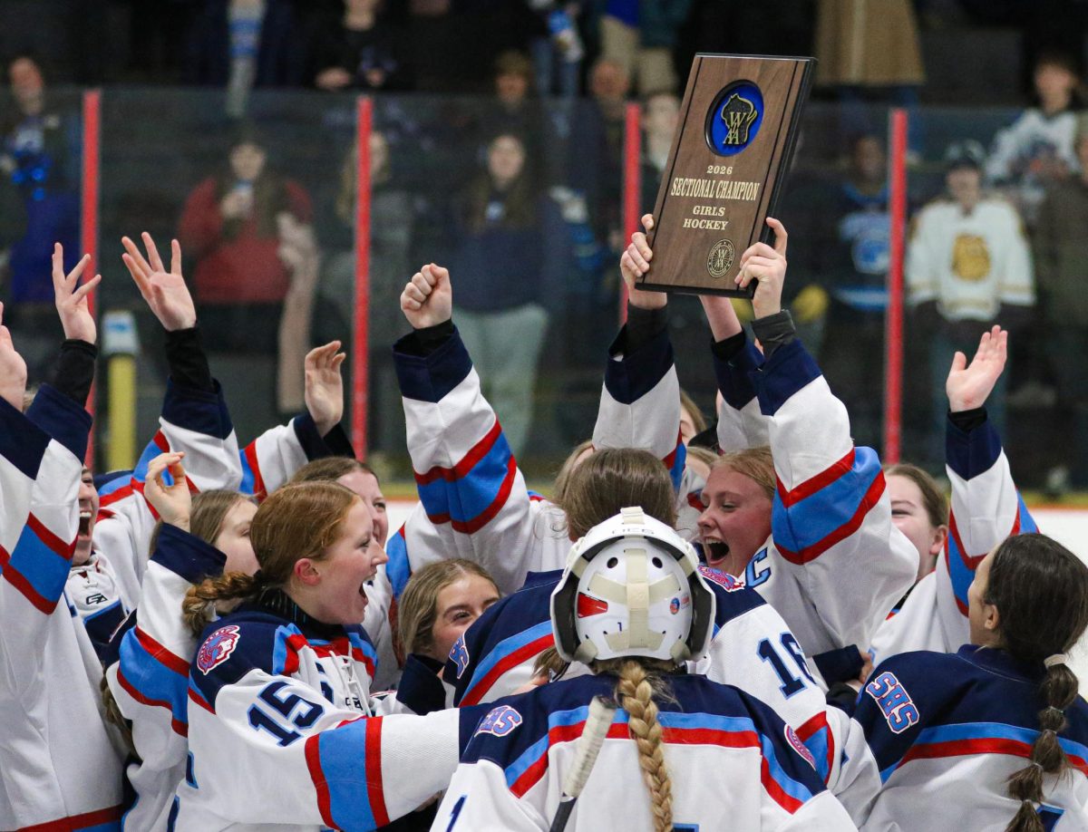 Senior captain Addy Benson presents the team with the Sectional Final Championship plaque on Feb. 28. The Spartans won 7-0 in the section final game over Northland Pines securing their place at the WIAA girls hockey state tournament.  