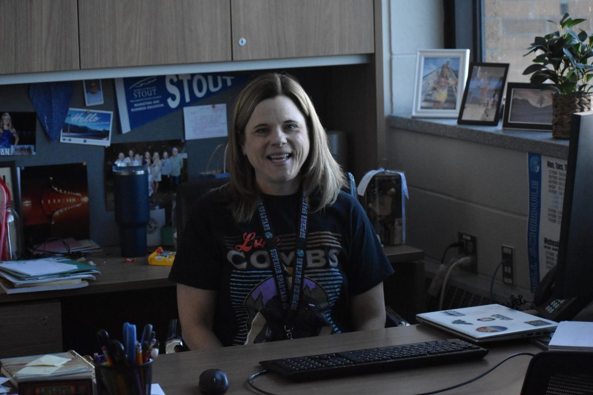 Heidi Sigfrids shows off her tour merch from a Luke Combs concert while she smiles at her desk on Feb 6, 2026. Sigfrids is a frequent concert goer in the Duluth/Superior area.
