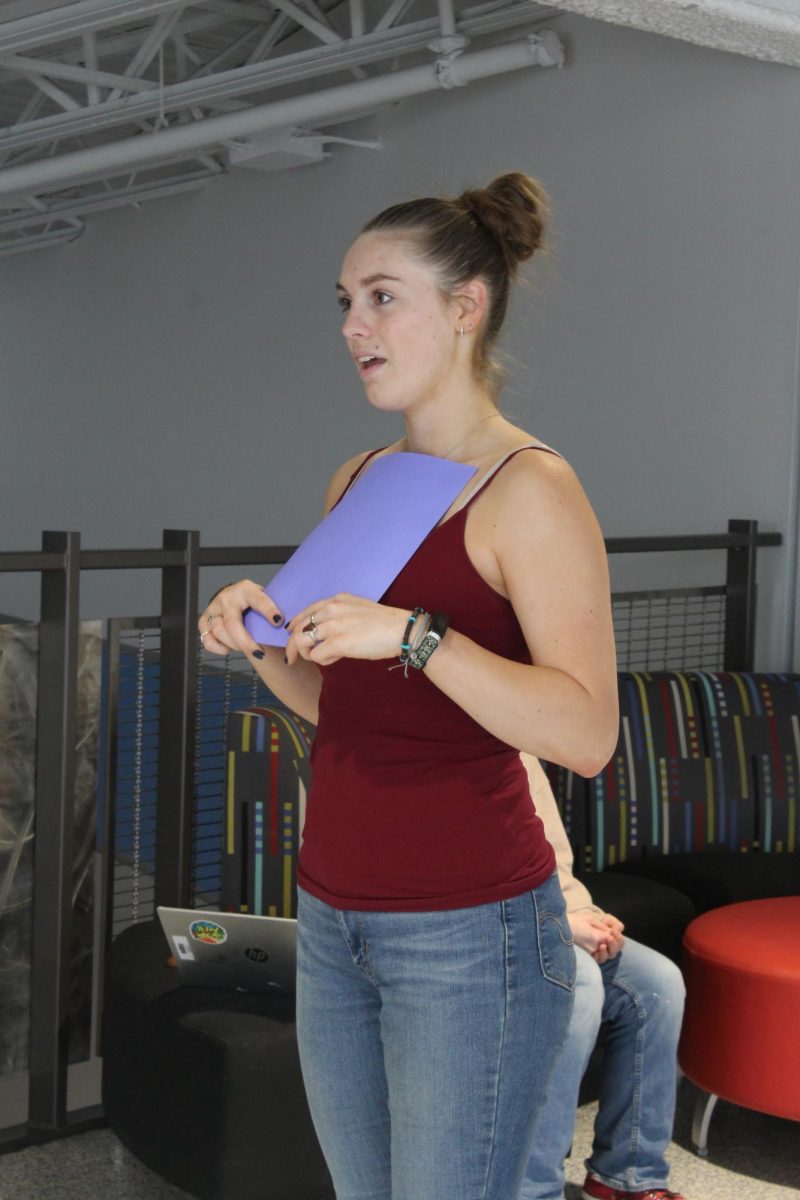 Senior Forensics Captain Abigail Watt introduces her speech to another student on the third floor balcony at Superior High School on Mar. 17, 2026.