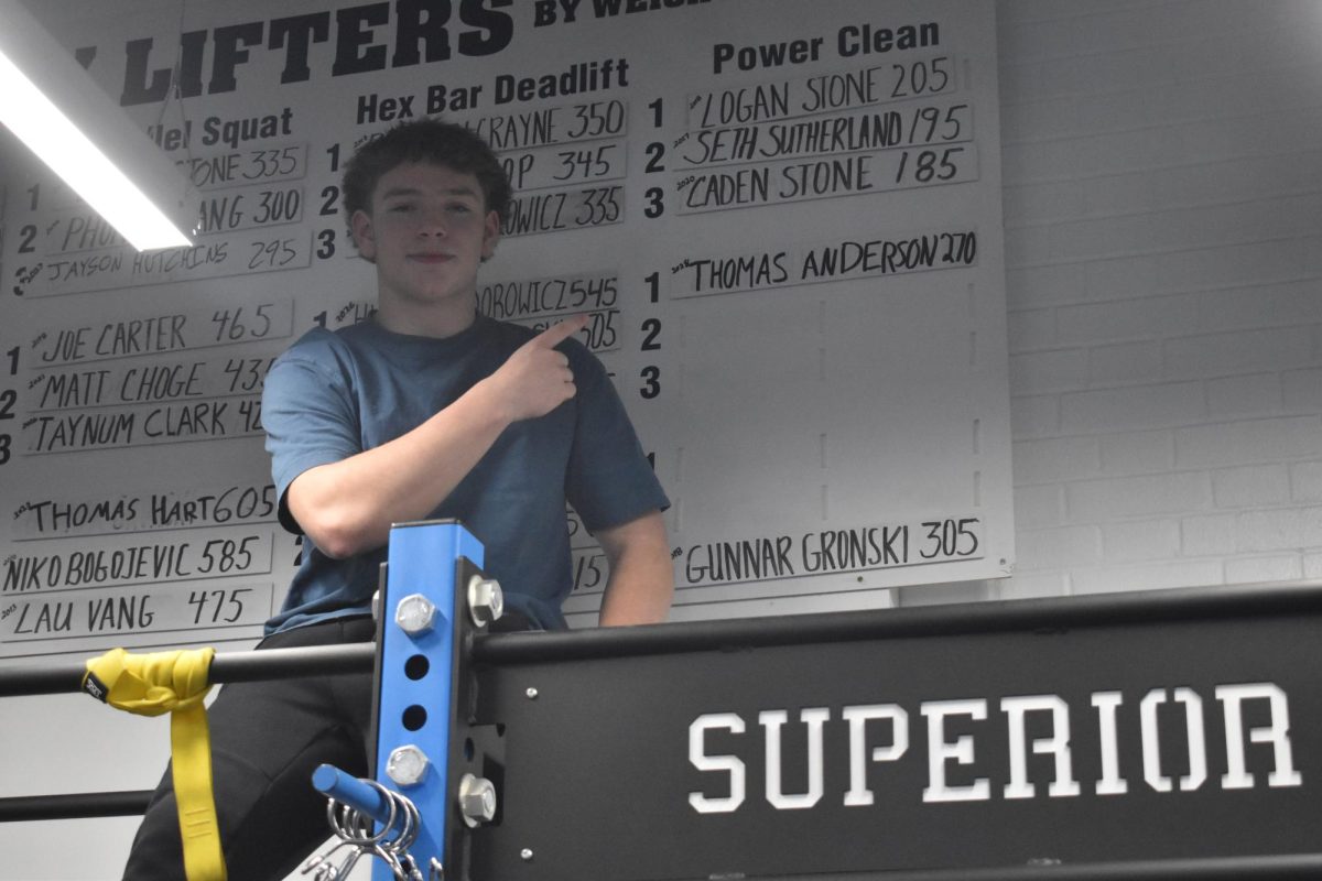 Sophomore Thomas Anderson points up at his record in the weight room on Feb. 12. 
