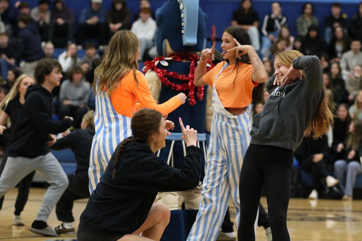 Juniors Lacey Skoglund (Left) and Avery Waletzko (Right) pose for “chicken in a hen house” during in the spring assembly on April 17, 2026