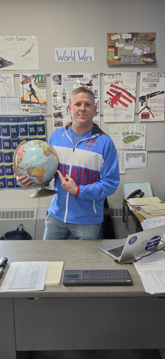 Chad Postal poses with a globe