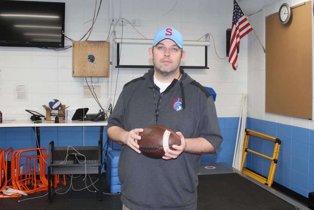 Coach Rob Scott poses with football.