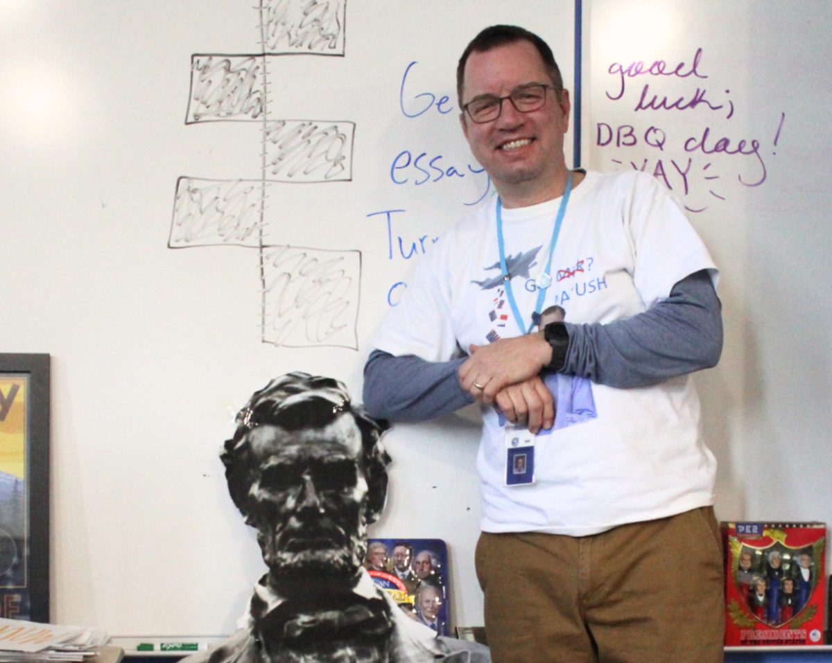 Mr. Smith poses with a cardboard cutout of Abraham Lincoln in his classroom. 
