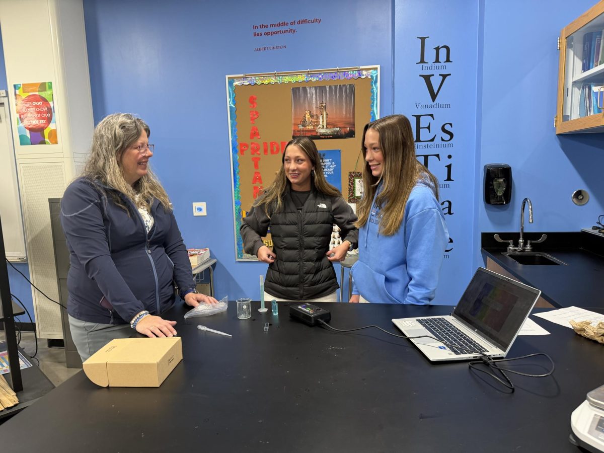 Chemistry teacher Angela Johnson helps Henleigh and Holland Helenius with a lab on April 15, 2026. 