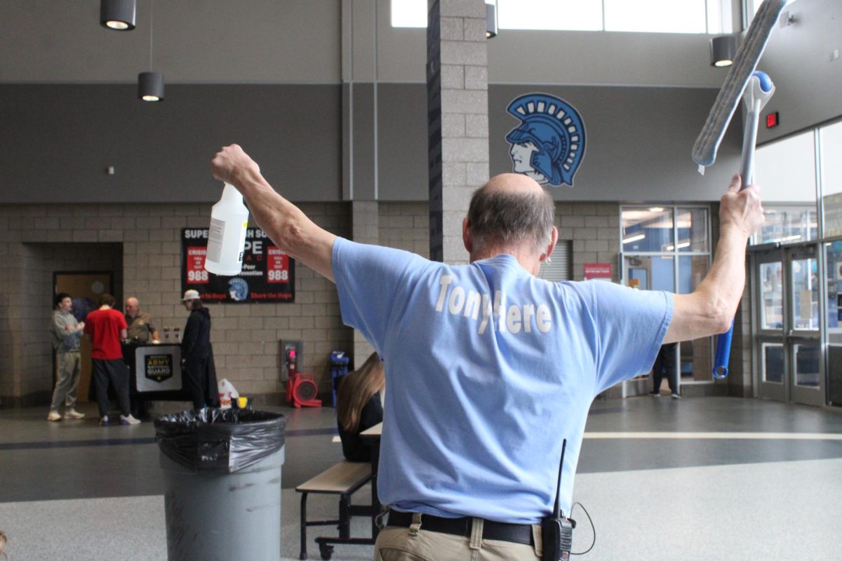 Superior High School Custodian Tony Parks walks through the cafeteria in response to students cheering for him on March 30.