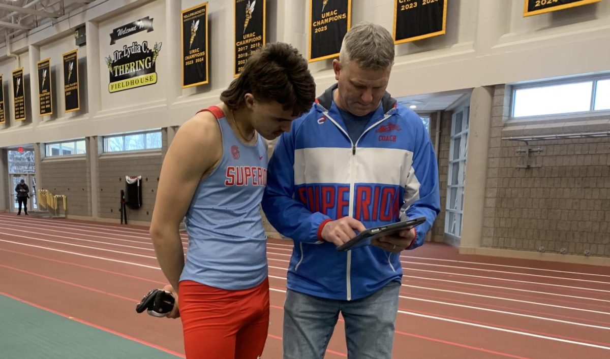 Chad Postal (right) talking to freshman Jasper Madrinich (Left) about a recording of the hurdles match that just happened on Apr. 2 at UWS, Northwestern's Simpson Invite track meet.